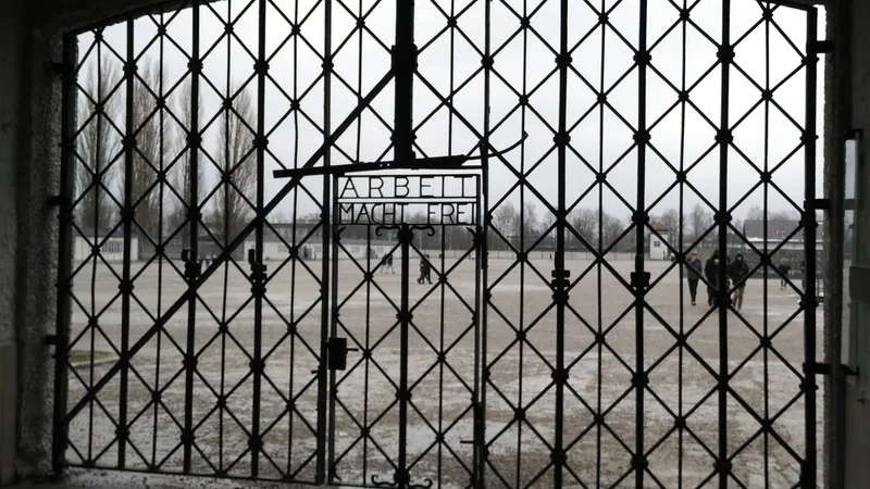 Puerta del antiguo campo de concentración de Dachau con el lema «Arbeit macht frei» y la plaza de recuento al fondo